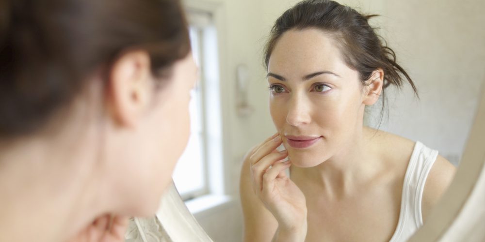 Woman looking at self in mirror.