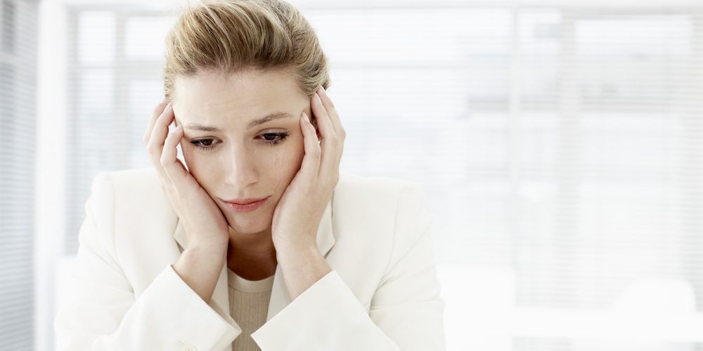 Businesswoman with head in hands