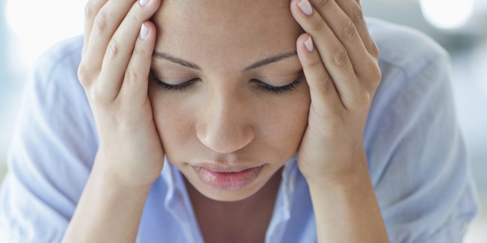 Woman with headache holding head